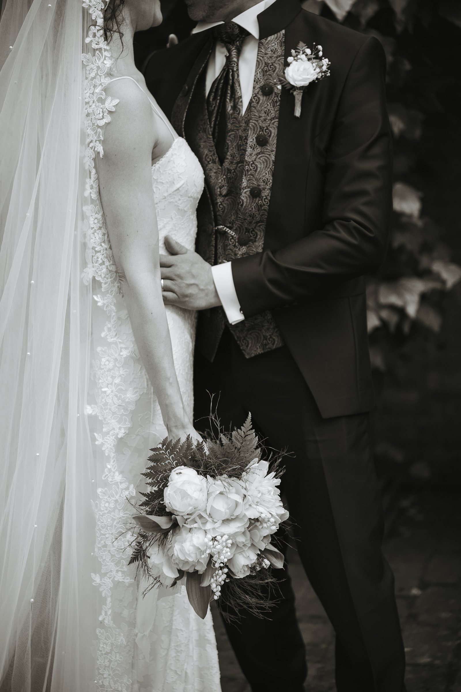 Dettaglio degli abiti e del bouquet degli sposi