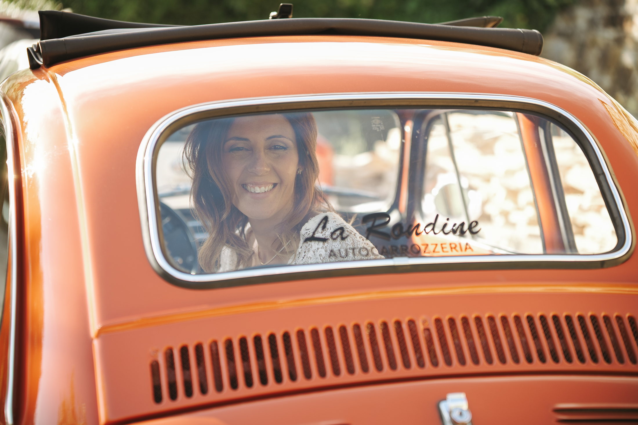 Ilenia sorride dal finestrino dell’auto d’epoca
