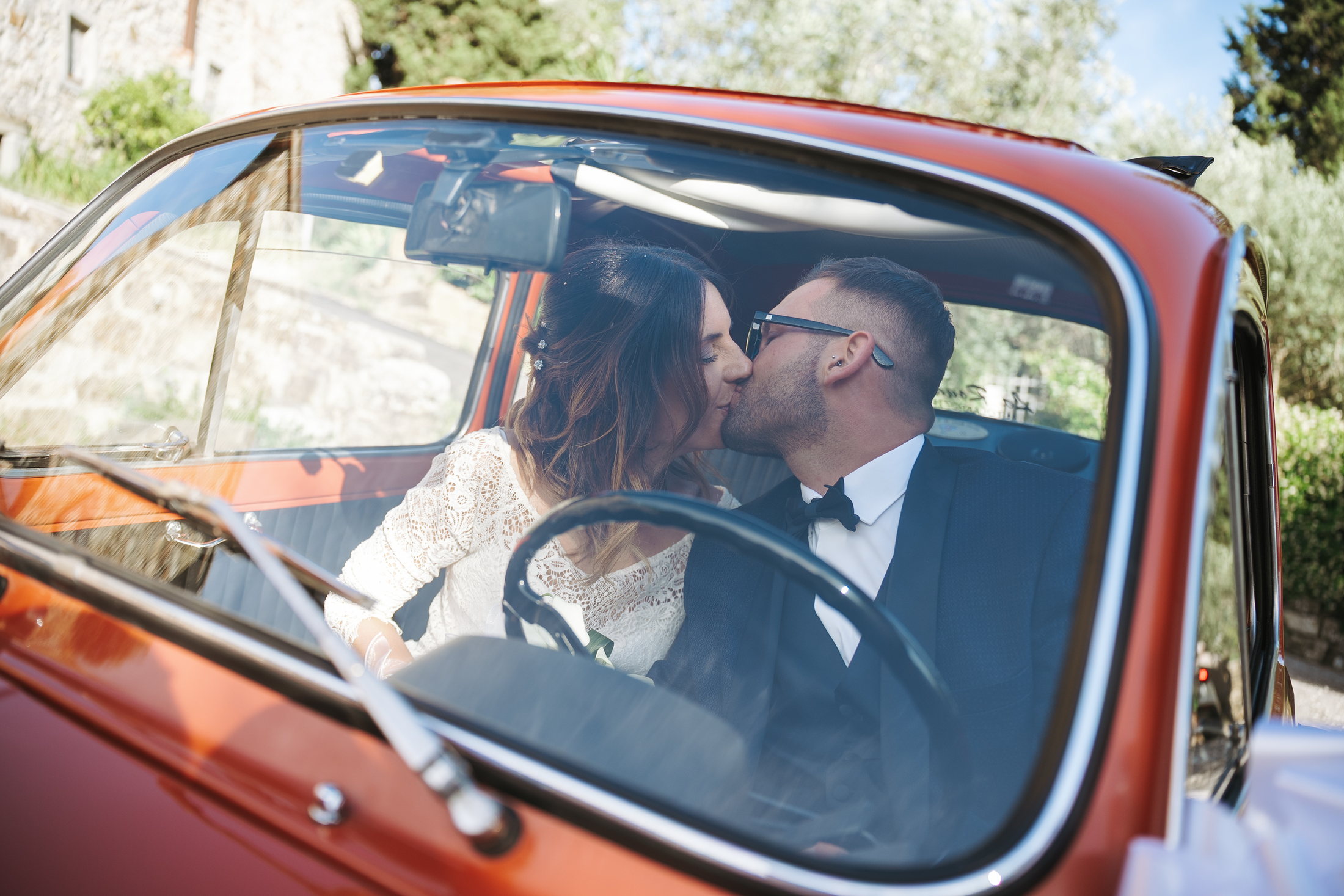 Ilenia e Lorenzo si baciano nella loro auto d’epoca