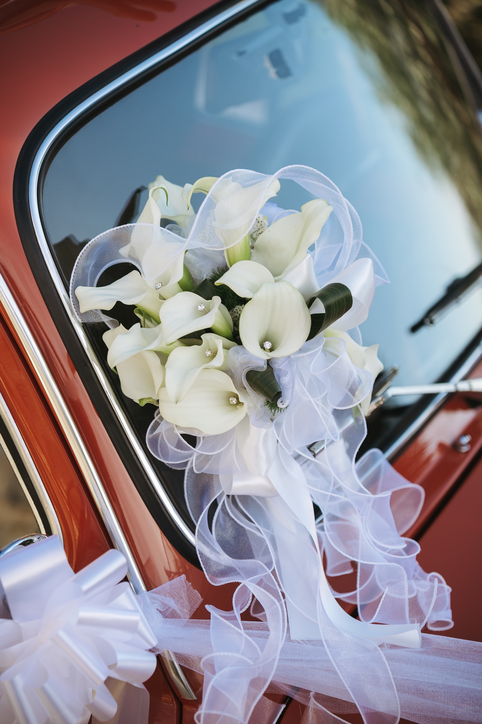 Il bouquet appoggiato sull’auto d’epoca degli sposi