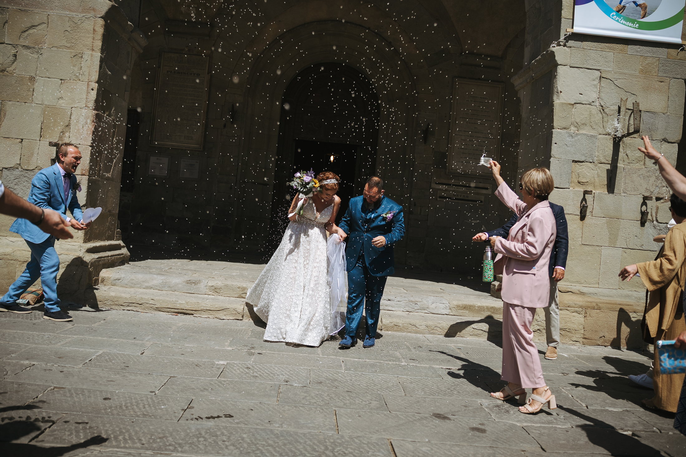 Marta e Marco escono dalla cerimonia tra gli invitati